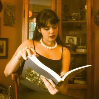 woman in pearls reading book