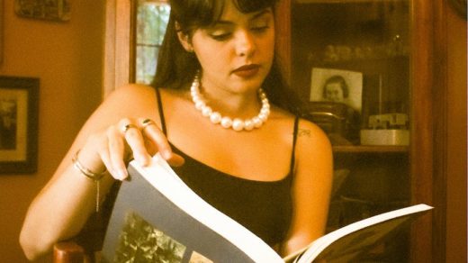 woman in pearls reading book