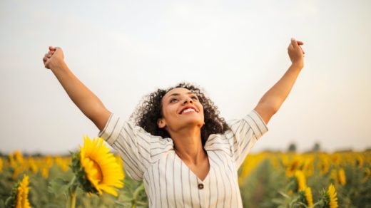 photo of woman standing on sunflower field