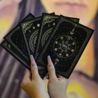 close up of woman holding tarot cards