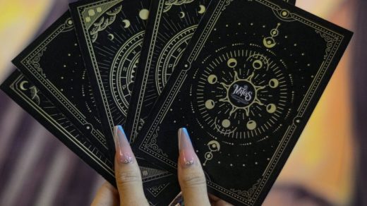 close up of woman holding tarot cards