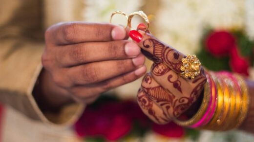 man and woman holding wedding rings