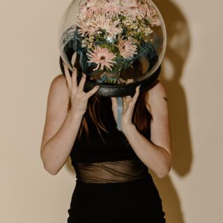 woman in black tank top and black skirt holding desk globe