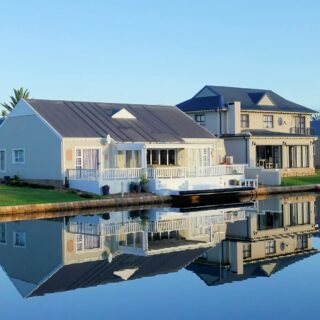 white single story houses beside body of water