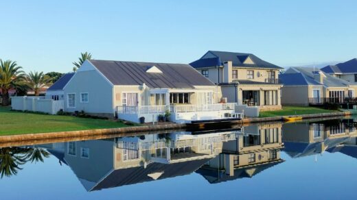 white single story houses beside body of water