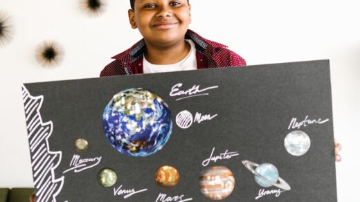a kid holding a board while smiling at the camera