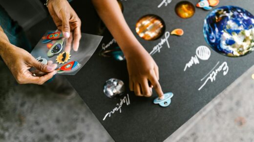 hand of a child putting stickers on a gray board