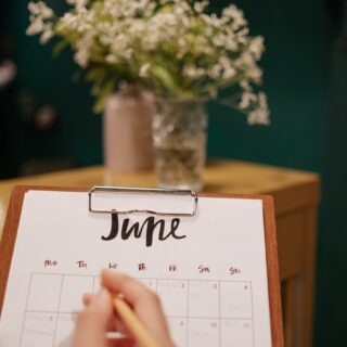person holding a calendar and clipboard