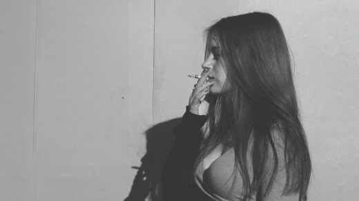 grayscale photo of a woman smoking cigarette