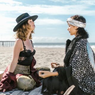two women sitting on the beach