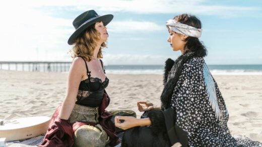 two women sitting on the beach