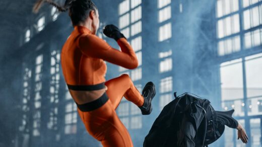 woman in orange and black long sleeve shirt and pants fighting