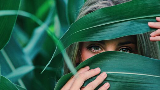 woman covering her face with corn leaves