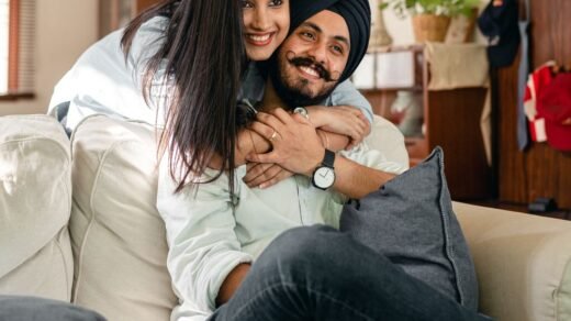 ethnic woman embracing husband on sofa in living room